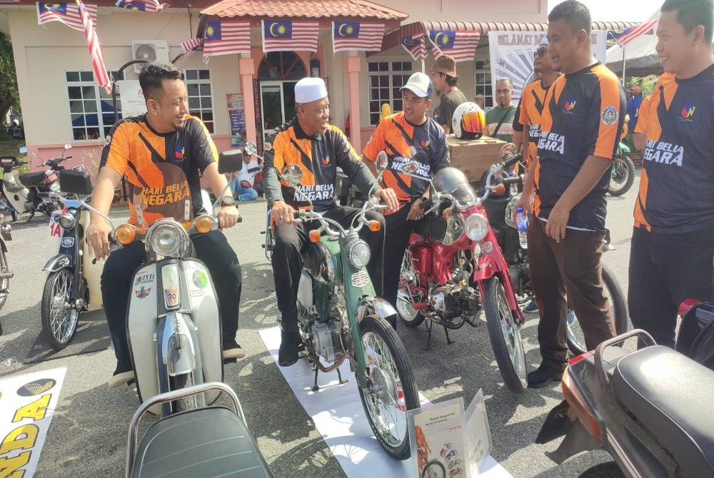 Exco Penerangan, Komunikasi dan Multimedia Kedah, Datuk Wan Romani Wan Salin (dua, kiri) cuba menunggang motosikal sempena Sambutan Hari Belia Negara Peringkat Daerah Pokok Sena di Desa Keda Kampung Bukit, pada Sabtu.