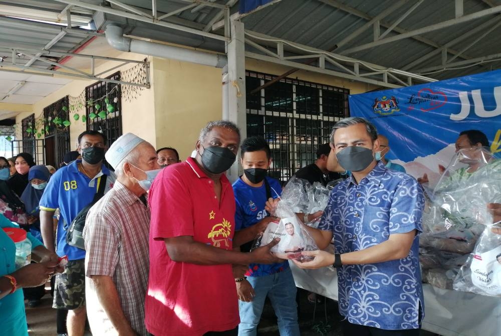 Fahmi (kanan) pada Program Jualan Amal Prihatin Rakyat, Ayam Segar Bersih di Dewan Persatuan Penduduk Flat Seri Pahang di sini pada Ahad.