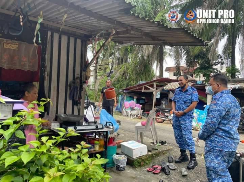 Kamal Moktar (tengah) dan Mohamad Asnizam meninjau keadaan banjir kilat yang surut di Kampung Laut Batu 10, Skudai, Johor Bahru, pada Ahad