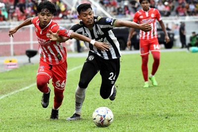Pemain Kelantan, Mohamad Ikhwan Yazek (kiri) dihalang pemain TFC II, Muhammad Safwan Mazlan dalam aksi perlawanan Liga Premier di Stadium Sultan Muhammad IV, Kota Bharu pada Ahad.