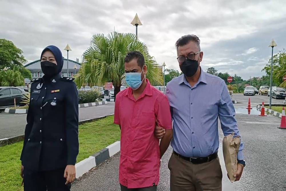 Mohammad Fadhil (tengah) diiringi pegawai polis untuk dituduh di Mahkamah Majistret Alor Setar pada Isnin.