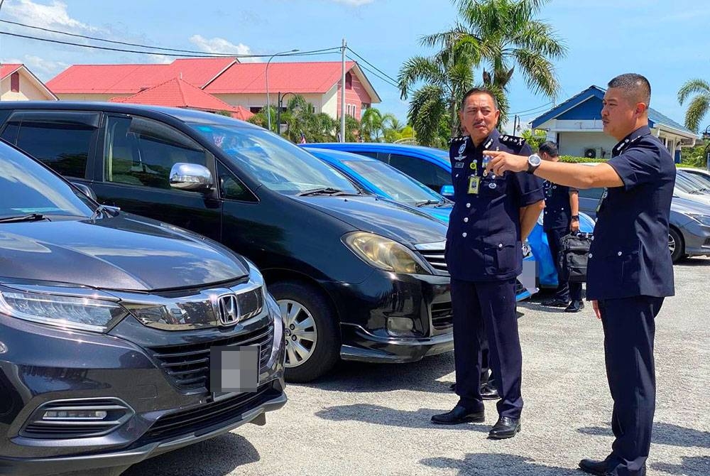 Pemangku Ketua Polis Kelantan, Datuk Muhamad Zaki Harun (kiri) menunjukkan kereta yang dirampas hasil serbuan ke atas sebuah rumah di Kampung Belukar Pauh, Panji, Kota Bharu yang dijadikan transit PATI, pada Selasa lalu.