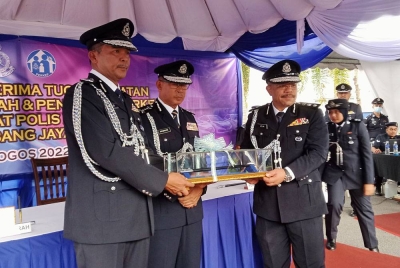 Abdul Khalid (kiri) menyerahkan tongkat kuasa kepada Wan Azlan (kanan) sambil disaksikan Arjunaidi dalam Majlis serah terima tugas yang berlangsung di Ibu Pejabat Polis Daerah (IPD) Subang Jaya pada Isnin.