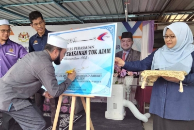 Nik Zawawi menandatangani plak Majlis Perasmian Anjung Perikanan Tok Ajam sempena Program Pemantapan MyKomuniti Perikanan (MyKP), myAgroprenuer Perikanan (myAP) dan Perasmian Anjung Perikanan Tok Ajam, pada Isnin.