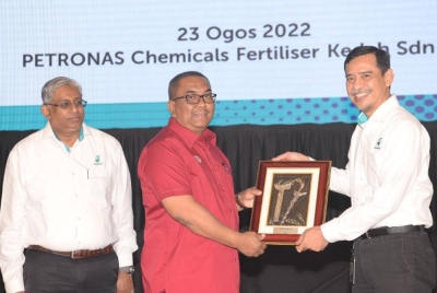 Mohd Yusri (kanan) menyampaikan cenderahati kepada Muhammad Sanusi ketika melancarkan projek loji melamina di Kompleks Petronas Chemical Fertiliser Kedah Sdn Bhd di Gurun pada Selasa.
