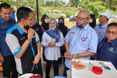 Noh (dua dari kanan) sambil diiringi Pegawai Pendidikan Daerah Kuala Selangor, Mohd Azuan Mohd Nawawi (kiri) semasa lawatan ke tapak gerai dan jualan pada Majlis Perasmian Kuiz Koperasi Daerah Kuala Selangor di SMK Pengkalan Permatang pada Selasa.