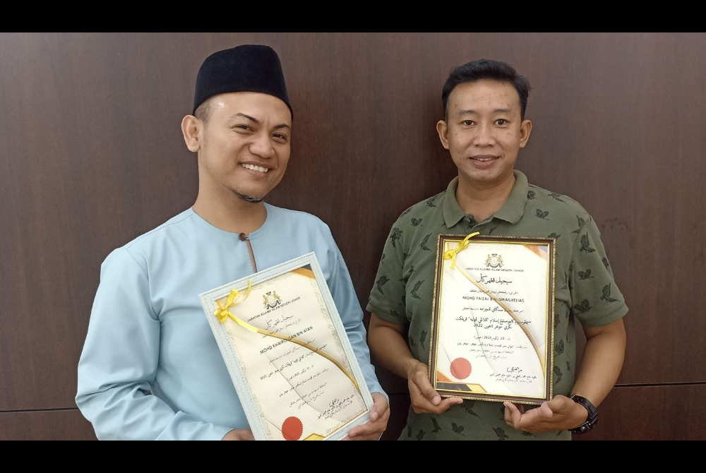 Mohd Khairolizan (kiri) dan Mohd Faizal (kanan) menerima sijil penghargaan pada Simposium Kaunseling Islam 'Pelangi Islam' di Dewan Besar, Pusat Islam Iskandar pada Selasa.