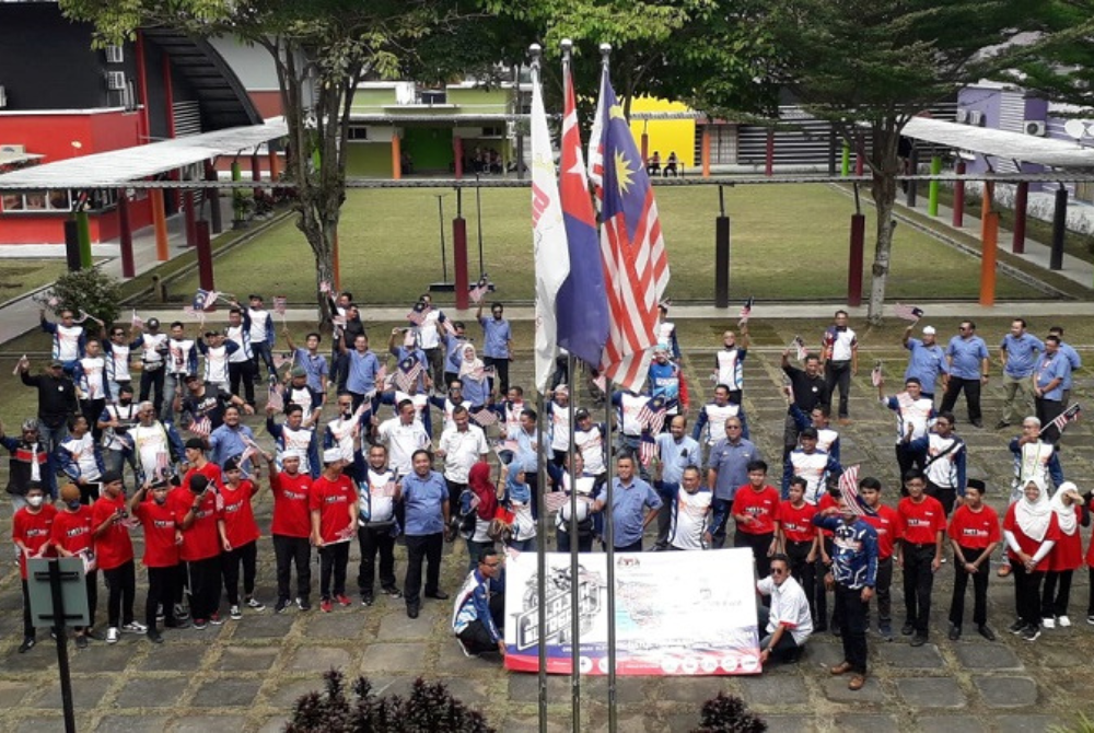 Awang dan para pelatih mengibarkan Jalur Gemilang sempena sambutan Hari Kebangsaan dalam program Jelajah Outreach TVET di Pusat Giat Mara Pasir Gudang, Johor Bahru pada Rabu.