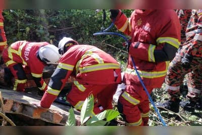 Pihak bomba mengeluarkan mangsa yang dihempap dinding konkrit dalam kejadian di Kampung Padang Midin, di Kuala Terengganu, pada Rabu. - Foto Ihsan Bomba