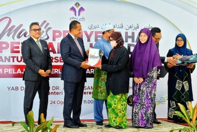 Ahmad Samsuri (dua dari kiri) menyampaikan wang pendahuluan diri dan bantuan persediaan penerima Biasiswa Skim Pelajar Cemerlang Luar Negara Tahun 2022 Yayasan Terengganu di Wisma Darul Iman pada Rabu.