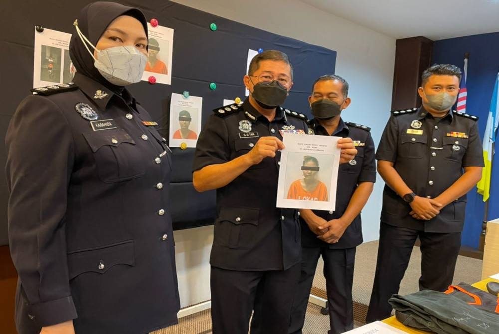 Cheng San (dua dari kiri) menunjukkan gambar suspek utama yang ditahan untuk membantu siasatan.