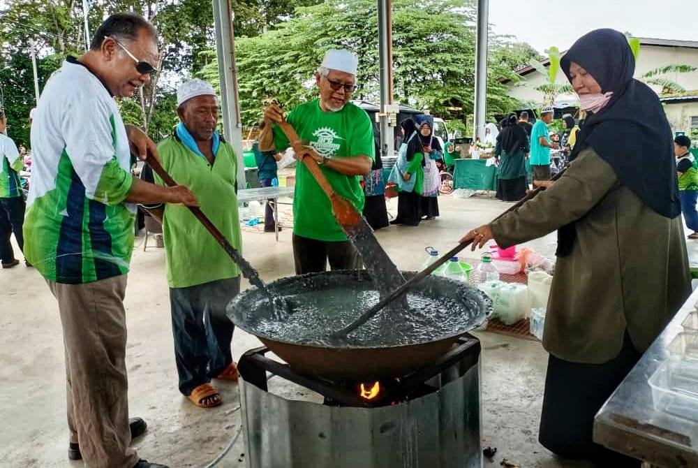 Mohd Hayati (dua dari kanan) sedang mengacau bubur asyura pada Program Asyura Perdana Pas Kawasan Pendang di sini pada Khamis.
