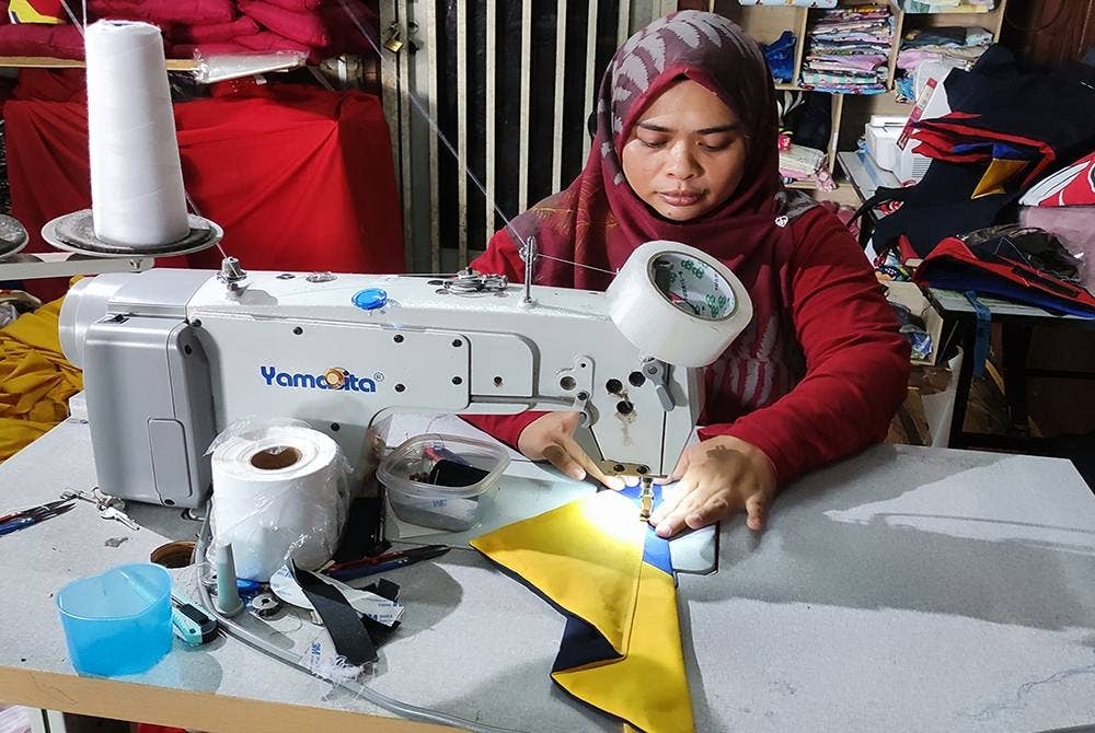 Norwilia menjahit tanjak di kedainya di Bukit Tunggal, Kuala Nerus.