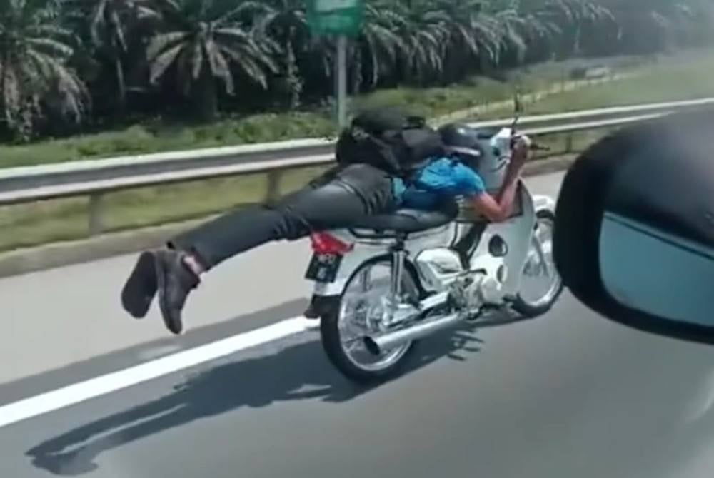 Tangkap layar dari video yang tular memaparkan aksi 'Superman' dilakukan seorang penunggang motosikal sebelum dia ditahan polis di LPT1, Kemaman pada Sabtu. - Foto media sosial