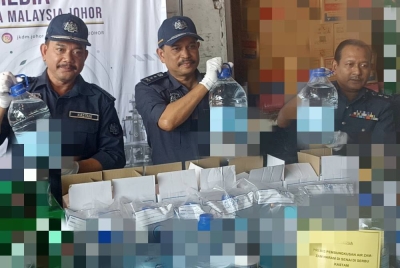 Sazali (dua dari kiri) menunjukkan sebahagian daripada 238 botol air zamzam dipercayai tiruan yang dirampas pada sidang akhbar di Menara Kastam, Johor Bahru pada Ahad.