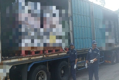 Sazali (kiri) menunjukkan minuman keras yang dirampas di dalam sebuah kontena pada sidang media di Menara Kastam Johor Bahru pada Ahad.