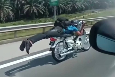 Tangkap layar dari video yang tular memaparkan aksi 'Superman' dilakukan seorang penunggang motosikal sebelum dia ditahan polis di LPT1, Kemaman pada Sabtu. - Foto media sosial