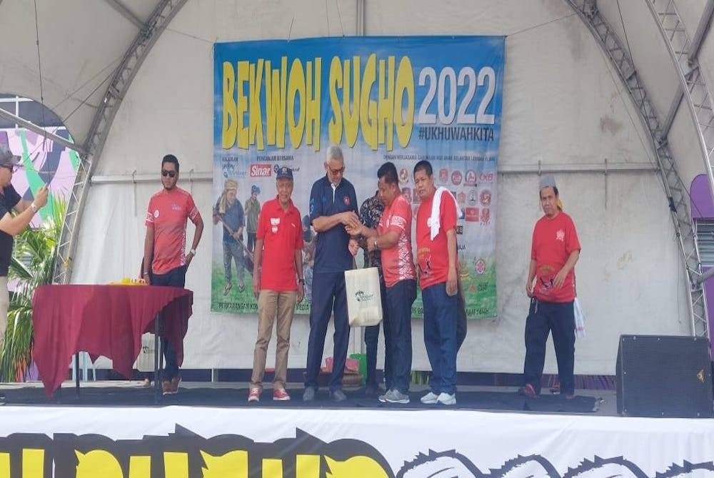 Khalid (tengah) menerima cendera hati sempena perasmian program ‘Bekwoh Sugho Anok Kelate 2022' di Kompleks Karangkraf, Shah Alam pada Ahad.