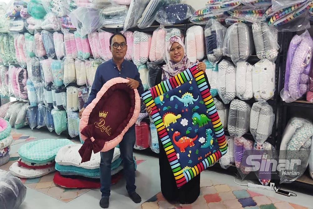 Suriya (kanan) bersama Mohd Badrul menunjukkan tempahan set tilam kekabu yang telah siap di kedai mereka di Taman Senangin, Alor Setar.