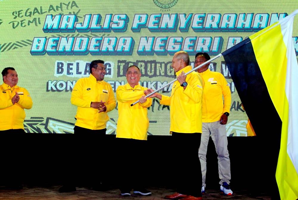Saarani (tengah) serah Bendera Perak 'Belang Tarung Tiga Warna' kepada Ketua Kontinjen Sukma Perak, Johari Sham Ahmad Shohor Affendi (dua dari kanan) pada Majlis Penyerahan Bendera Kontinjen Sukma Perak ke Temasya Sukma 2022 Kuala Lumpur hari ini. - Foto Bernama