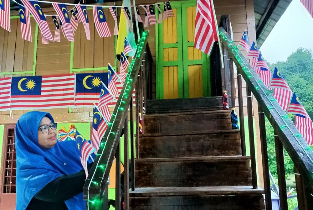 Siti Hajar menghiasi rumah pusaka yang didiami bersama suami dengan kibaran Jalur Gemilang.