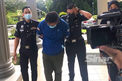 Mazlan (dua dari kiri) dibawa ke Mahkamah Pasir Mas untuk berdepan 10 tuduhan menipu. 