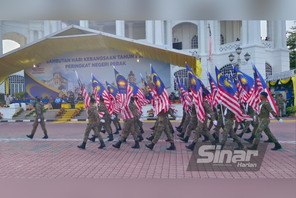 Kontinjen pembawa bendera Malaysia berarak di hadapan Sultan Nazrin pada sambutan Hari Kebangsaan 2022 peringkat negeri Perak.