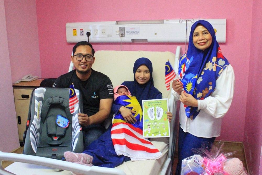 Wan Izzat Fahmi dan Dahliah (tengah) teruja menimang cahaya mata kedua mereka yang dilahirkan pada Hari Kebangsaan ke-65 di Hospital Pakar Perdana, Kota Bharu pada Rabu.