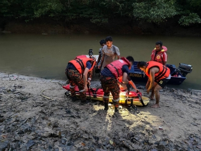Anggota bomba mengangkat mayat mangsa yang hanyut semasa menyeberang sungai. 