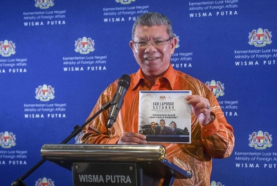 Saifuddin menunjukkan kad Laporan Setahun Kementerian Luar Negeri "Mengemudi Dasar Luar Pasca Pandemik" ketika sidang media di kementerian itu pada Khamis. - Foto Bernama