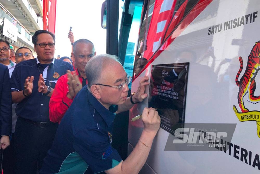 Ka Siong (kanan) menandatangani plak pada bas MRD di Kota Bharu pada Jumaat. - Foto Sinar Harian
