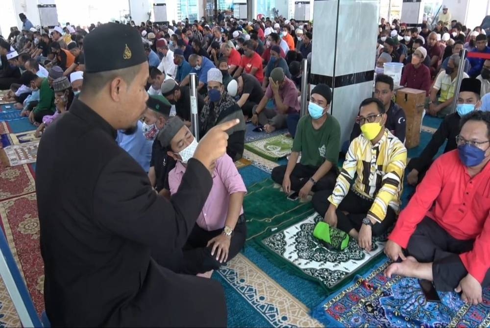Muhammad Nidzam memberi khidmat jurubahasa isyarat bagi membolehkan golongan istimewa memahami isi kandungan khutbah Jumaat.