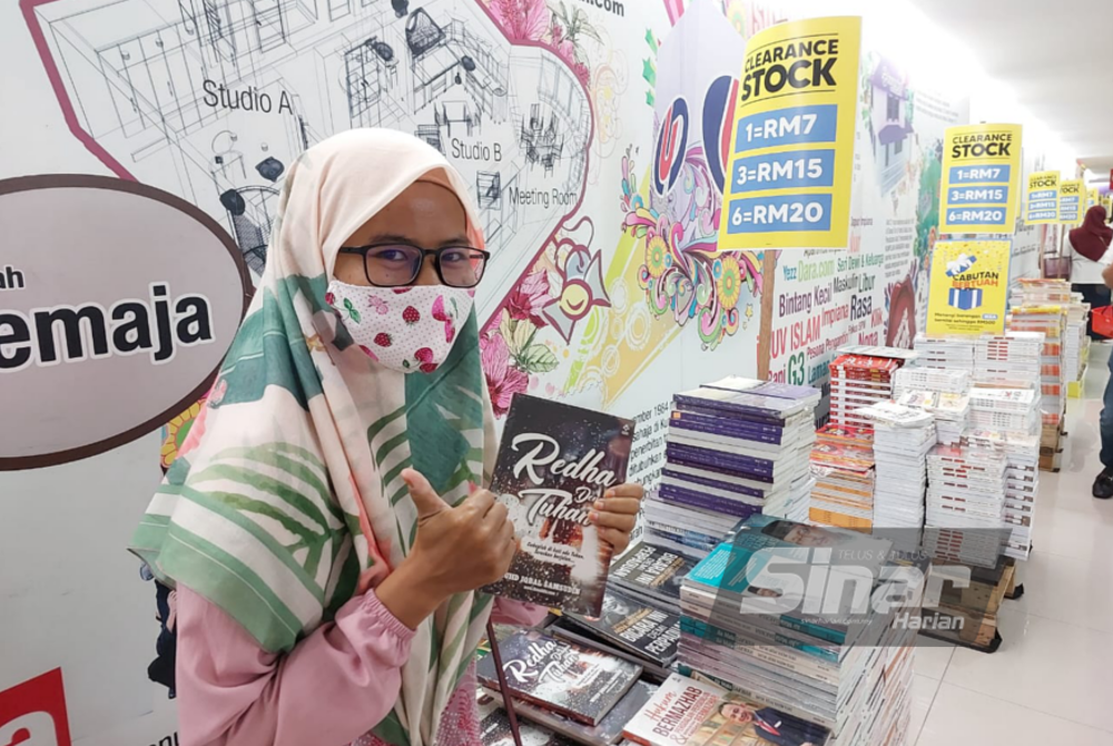 Pekerja swasta, Siti Zuhairah Mohd Ghazali, 41, menunjukkan buku yang dibelinya di jualan gudang pada Sabtu.