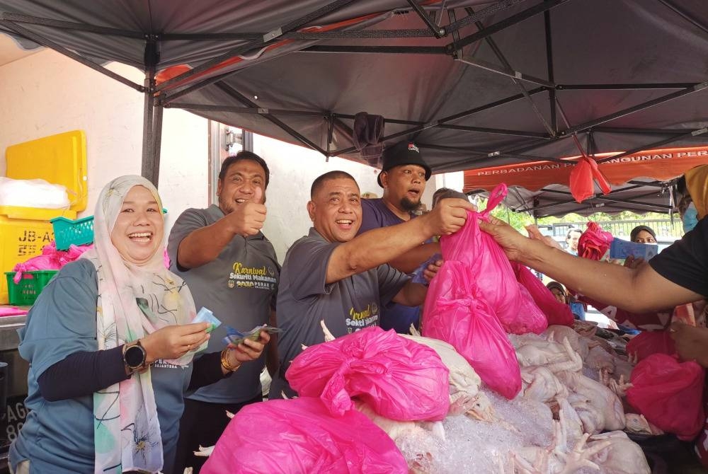 Saarani (tiga dari kiri) memeriahkan sesi jualan murah ayam pada harga RM4 seekor sempena Karnival Sekuriti Makanan@Perak Sejahtera 2030 di Dewan Millenium, Lubok Merbau di sini pada Ahad.