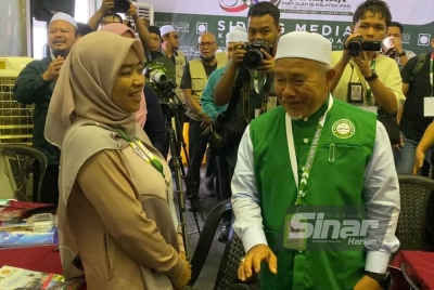 Tuan Ibrahim (kanan) beramah mesra dengan pemberita ketika melawat ke pusat media di Kompleks Pas Kedah pada Ahad.