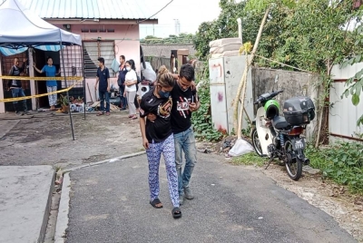 Nurul Ain Najihah Zulkifli, 27, yang cedera semasa cuba menyelamatkan dua anaknya dalam kebakaran dipapah suaminya pada Sabtu.