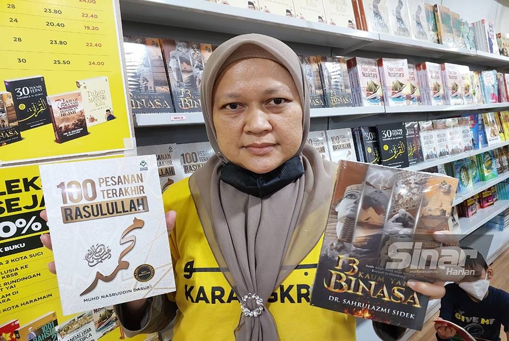 Roziyana menunjukan dua buah buku yang paling laris sepanjang jualan gudang iaitu 100 Pesanan Terakhir Rasulullah dan 13 Kaum Yang Binasa.