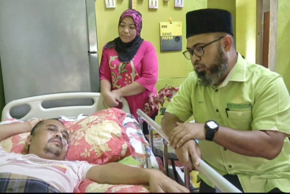 Asmadi (kiri) melawat dan menyampaikan sumbangan kepada Mohd Hairol yang lumpuh akibat diserang angin ahmar pada Julai lalu.