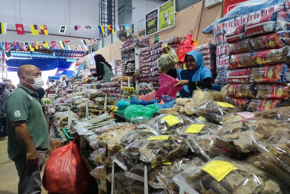 Rakiah sedang melayan pelanggan yang datang membeli keropok lekor di gerainya di sini pada Rabu.