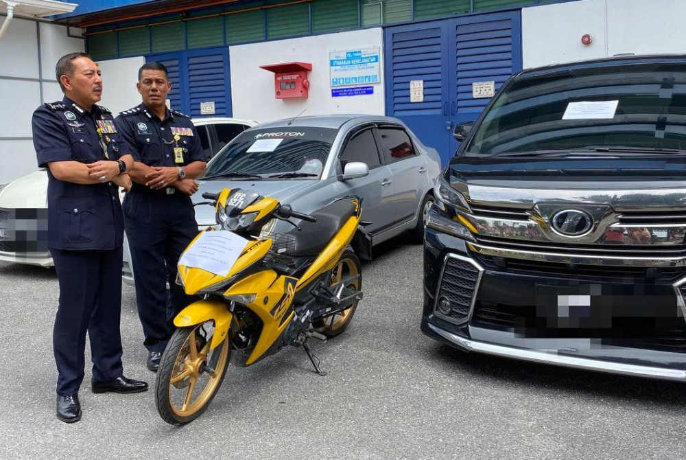 Muhamad Zaki (kiri) menunjukkan sebahagian daripada kenderaan yang dirampas.