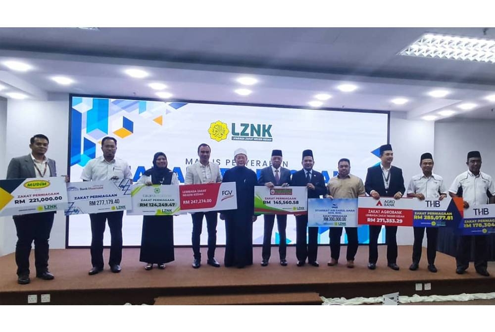 Zakaria (enam dari kiri) bersama wakil syarikat yang membayar zakat perniagaan di Menara Alor Setar pada Rabu.