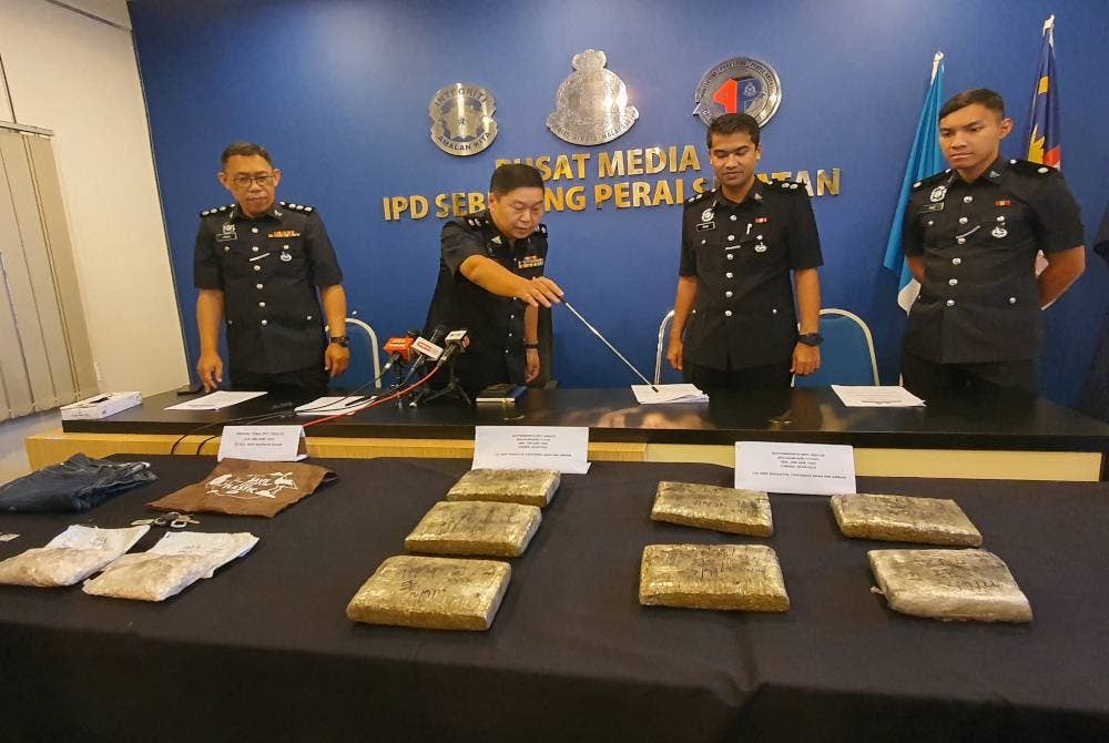 Chong Chern (dua dari kiri) menunjukkan dadah yang dirampas daripada sindiket.