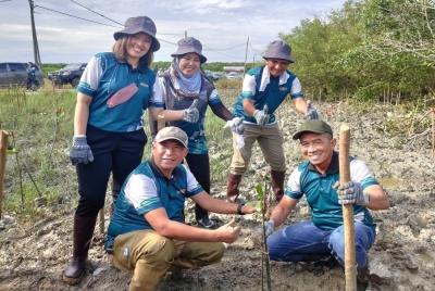 Mohd Nizom (kanan) menanam pokok bakau sebagai simbolik pada Program Penanaman Pokok Bakau KDEBWM, LHDN dan Jabatan Perhutanan Selangor di Hutan Simpan Kuala Bernam, Teluk Rhu Sungai Apong di sini pada Rabu.