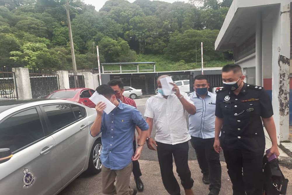 Tertuduh diiringi anggota polis ketika dibawa ke Mahkamah Majistret Johor Bahru pada Khamis.