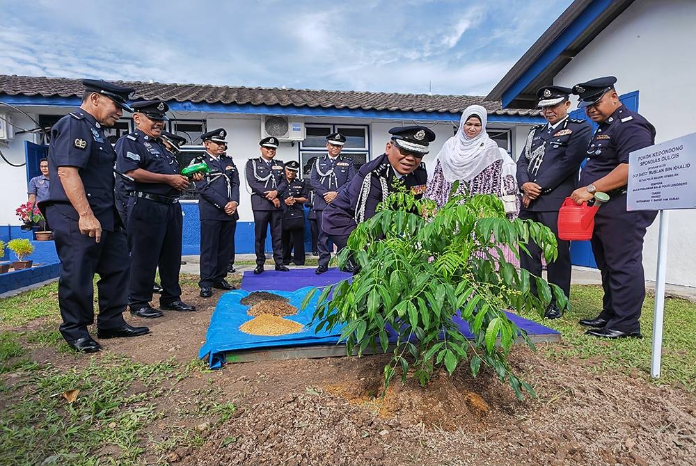 Ruslan menanam pokok kedondong sebagai simbolik perasmian Balai Polis Lenggeng.