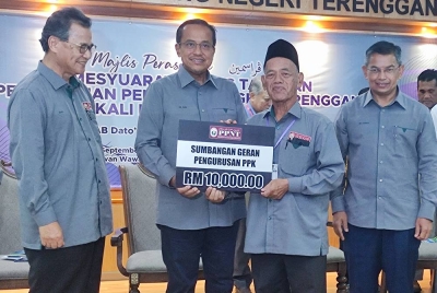 Ahmad Samsuri (dua dari kiri) menyampaikan sumbangan geran pengurusan PPK selepas merasmikan Mesyuarat Agung Tahunan Pertubuhan Peladang Negeri Terengganu kali ke-48 Tahun 2022 di Wisma Peladang pada Khamis.