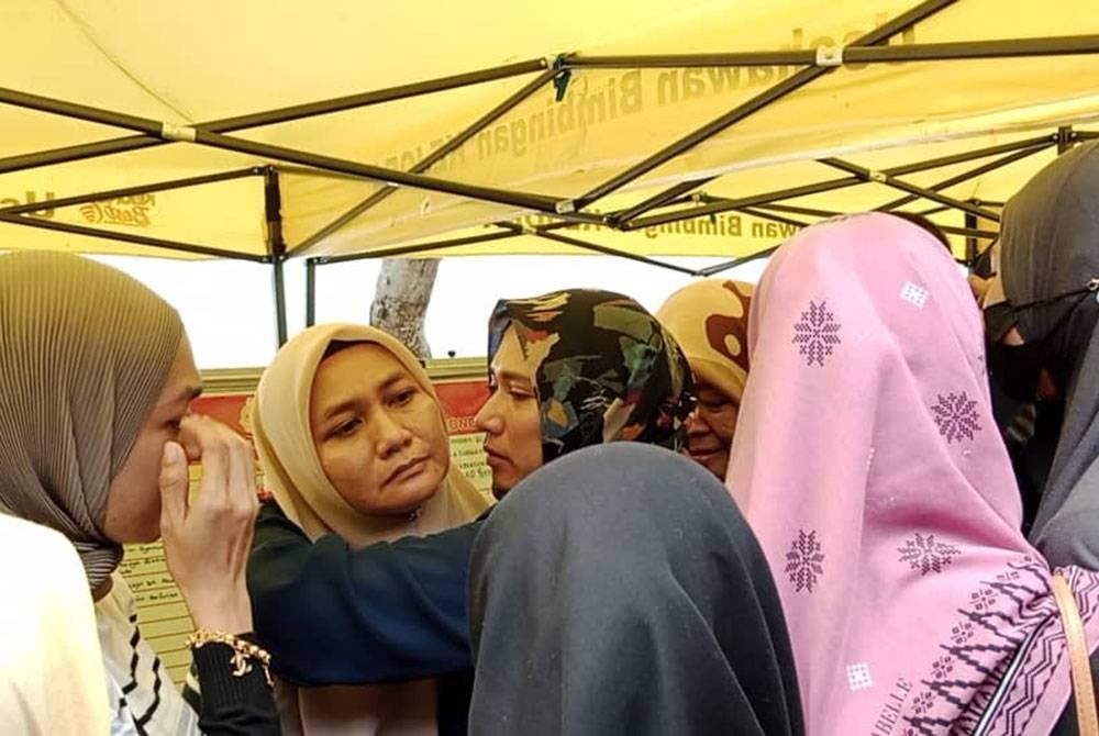 Radiah (dua dari kiri) dipeluk dan ditenteramkan rakan serta saudara-mara semasa operasi mencari anaknya yang hilang di Pantai Tanjung Balau, Bandar Penawar, Kota Tinggi, pada Jumaat.