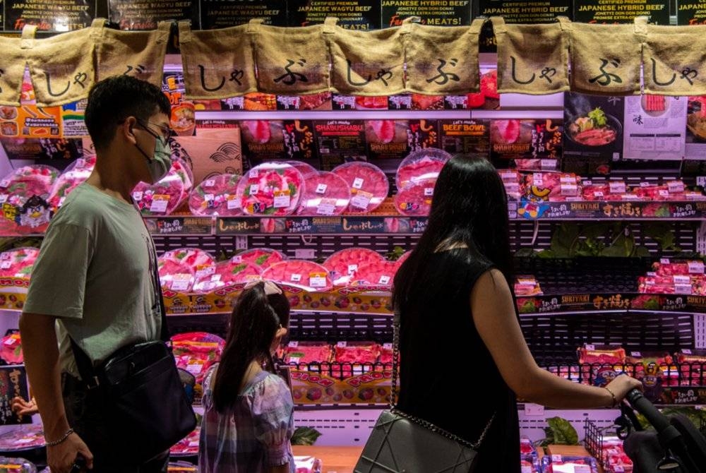 Pengunjung melihat pelbagai jenis potongan daging lembu wagyu disahkan halal yang terdapat di sebuah pasar raya. - Foto Bernama 