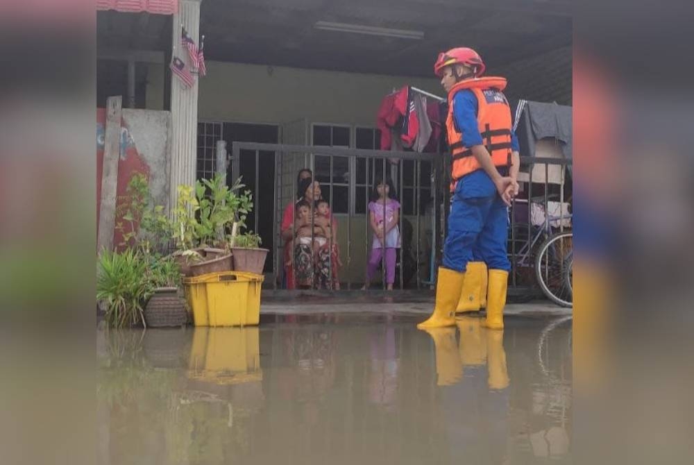 Anggota APM memantau keadaan kediaman penduduk yang terjejas akibat fenomena air pasang besar di Kuala Kedah. - Foto APM Kota Setar