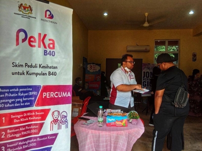 Mohd Fadzrel (kiri) memberikan penerangan mengenai skim PeKa B40 kepada penduduk yang hadir.